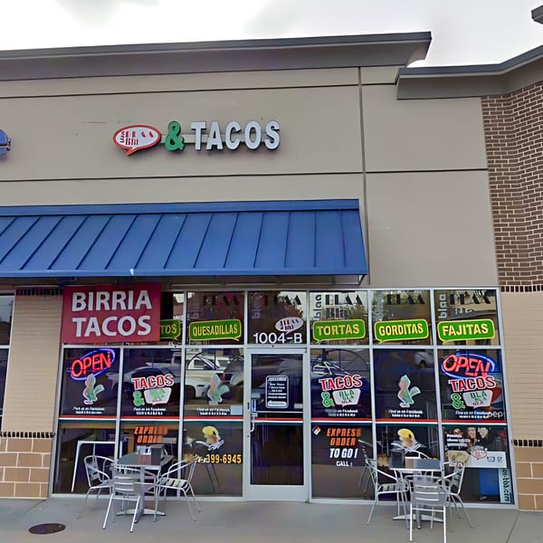 Exterior of Tacos & Bla Bla Bla, a Mexican restaurant, with outdoor seating and menu items displayed on windows.